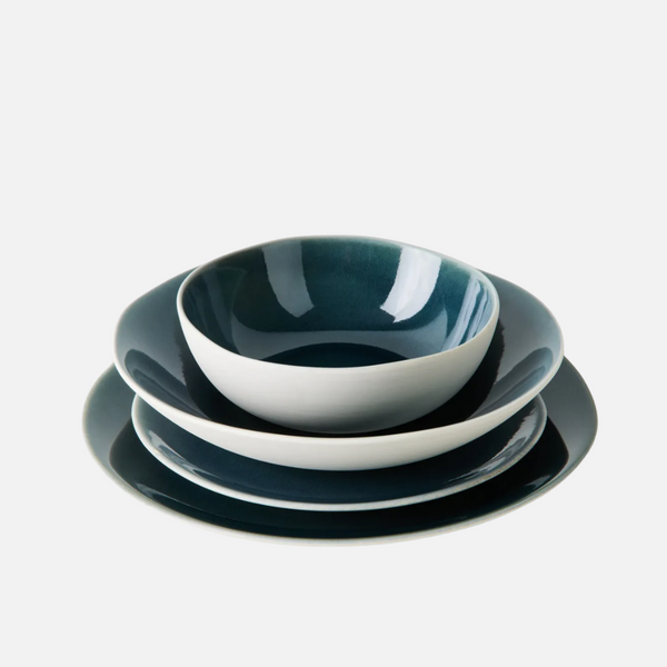 The Maguelone Outremer Dark Blue dinnerware set by Jars - Rosenthal features a deep bowl, a shallow bowl, and two plates in rich dark blue and white—beautifully arranged against a white background and ideal for any ceramic collection.
