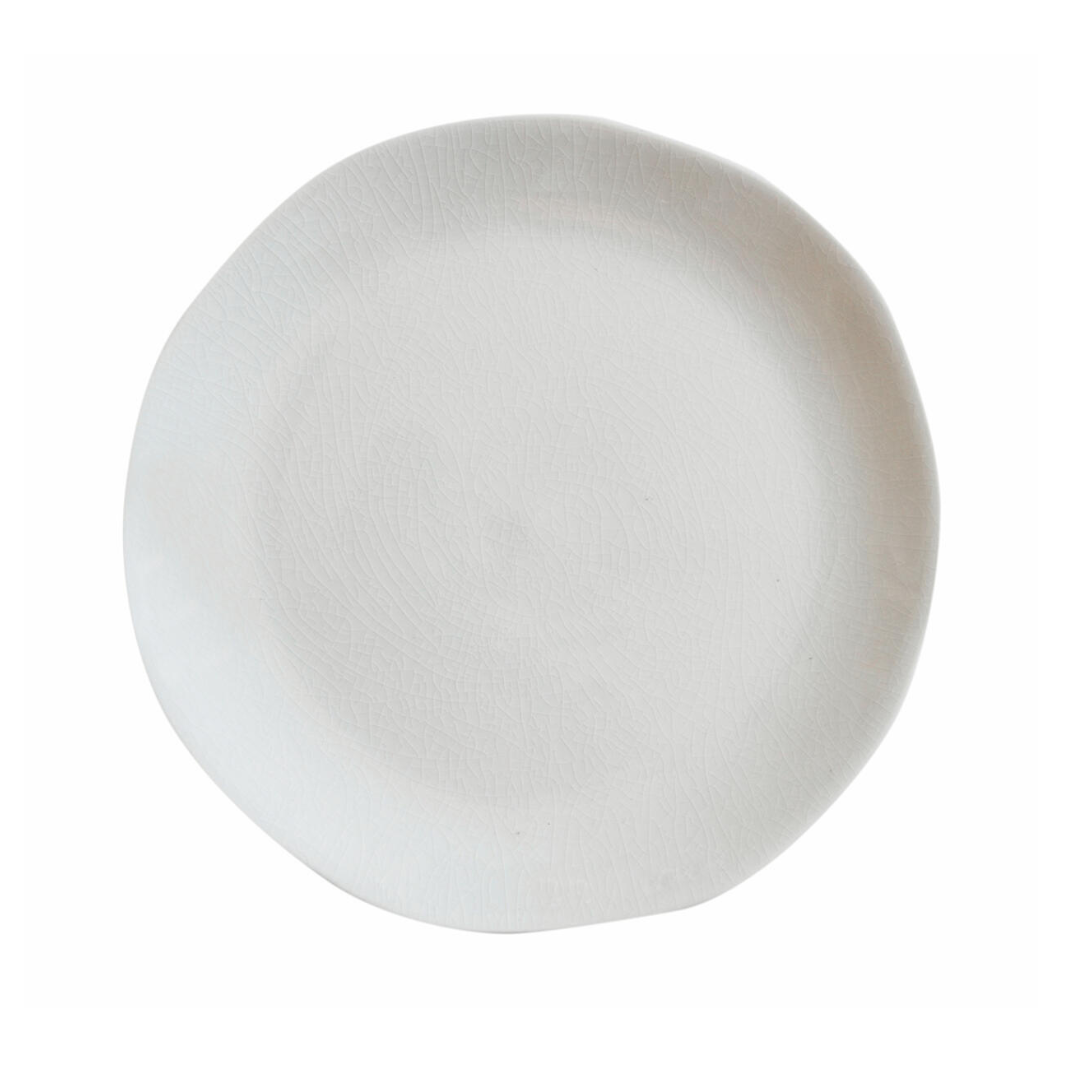 The Maguelone Dinnerware Quartz plate by Jars - Rosenthal is a round white ceramic piece with subtly uneven edges, capturing Mediterranean artisan style and pairing perfectly with other crackled glaze dinnerware.