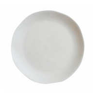 The Maguelone Dinnerware Quartz plate by Jars - Rosenthal is a round white ceramic piece with subtly uneven edges, capturing Mediterranean artisan style and pairing perfectly with other crackled glaze dinnerware.