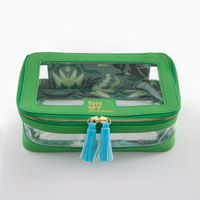 A green Mahjong Tile Storage Bag by Oh My Mahjong, featuring zippered closure with blue and white tassel pulls, transparent panels, and a decorative leafy interior lining. The stylish pouch is designed specifically for tile storage and displays a label that reads “OH MY MAHJONG.”.
