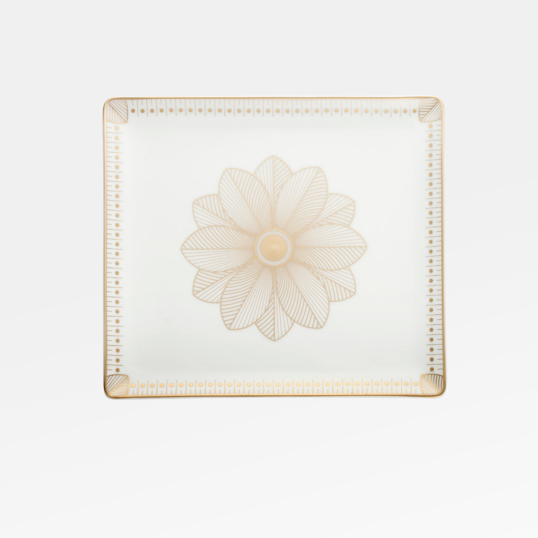 The Malmaison Porcelain Catchall Tray by Christofle is a square white Limoges porcelain piece with gold geometric accents, a detailed gold flower at the center, and Malmaison Impériale gold edging on the corners.
