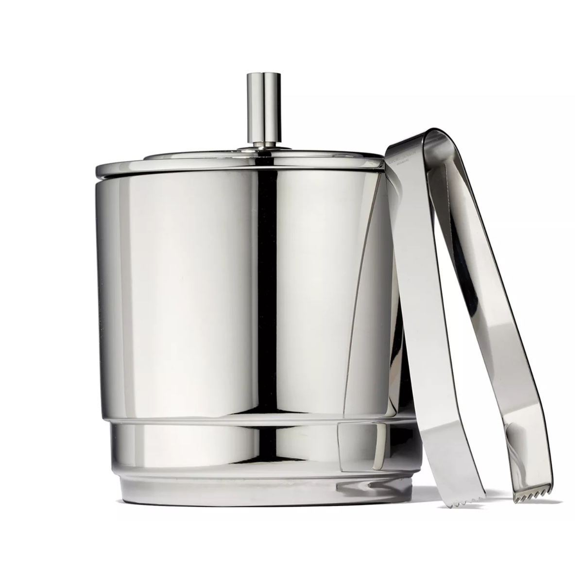 The Georg Jensen Manhattan Ice Bucket & Tong Set features a smooth, shiny finish and modern design inspired by Art Deco elegance, complete with a lid and matching tongs, set against a white background.