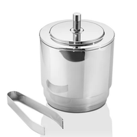 The Georg Jensen Manhattan Ice Bucket & Tong Set features a stainless steel bucket with a matching lid and handle, accompanied by metal tongs, all displayed on a plain white background in classic Art Deco style.