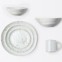 A Blue Pheasant Marcus Dinnerware Set in White Salt Glaze, featuring two bowls, two differently sized plates, and a mug, is arranged neatly on a white background.