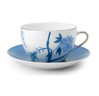 The Marie Daâge Bouquet De Vie 1 teacup and saucer features hand-painted blue floral motifs on white Limoges porcelain, with a blue rim and gold edge—a stunning piece of tableware from Marie Daâge.