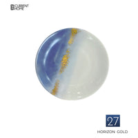 The Marie Daâge Horizon Gold Dinnerware plate features a blue and white gradient with a hand-painted gold streak, style number 27, from the brand Marie Daâge. The Current Home logo appears in the top left corner.