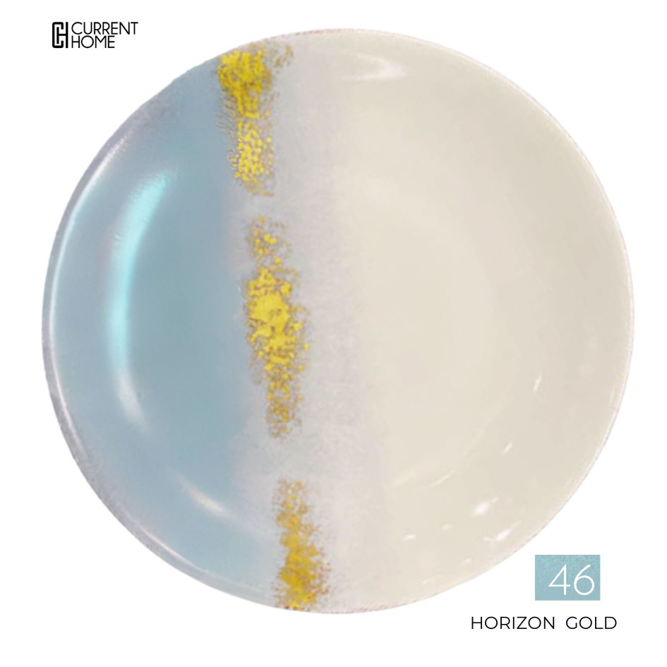 The Marie Daâge Horizon Gold Dinnerware features a round ceramic plate, hand-painted with soft blue and creamy white sides, separated by a textured vertical gold-and-white band.