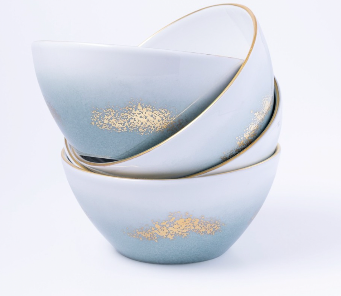 Three stacked Marie Daâge Horizon Gold Dinnerware bowls by Marie Daâge, with a blue and white gradient, gold textured accents, and slim gold rims, elegantly displayed against a plain white background.