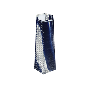 The BB Faceted Mini Vase by Matt Kolbrener is a tall, rectangular handblown glass vase with a textured surface and deep blue and clear panels—an eye-catching piece of industrial design set against a white background.