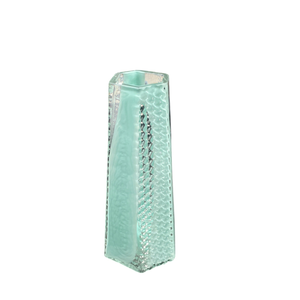 The BB Faceted Mini Vase by Matt Kolbrener is a tall, rectangular, light blue handblown glass vase featuring a textured honeycomb pattern and modern industrial design, shown upright against a white background.