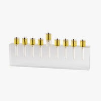 The Apeloig Modern Acrylic Oil Menorah features nine gold candle holders on a clear base. This customizable menorah brings elegance and contemporary style to your Hanukkah celebrations.