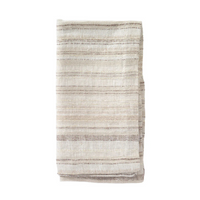 A folded, cream-colored napkin from the Bodrum Midas Napkin Set of 4, featuring subtle beige and brown horizontal stripes, is displayed on a white background.