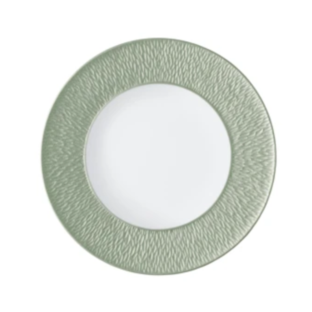 A Raynaud Mineral Irise Dinnerware - Celadon plate is shown from above, with a textured light green rim and smooth white center, set against a plain background.