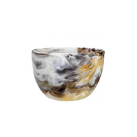 The Nashi Home Swirl Colored Resin Deep Bowl, featuring a marbled white, black, gray, and yellow design, sits on a plain white background. This stylish shatterproof resin bowl is a practical addition to any kitchen.