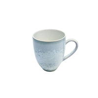 The Song Ocean Dinnerware mug by Jaune De Chrome features a white ceramic finish with a subtle textured pattern and curved handle, capturing the timeless elegance of French design against a plain white backdrop.
