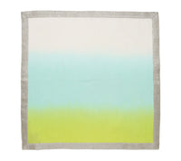 The Kim Seybert Dip Dye Napkins - Cool Tones (Set of 4) feature a square shape, metallic foil border, and a gradient center fading from off-white to light blue to bright yellow-green.