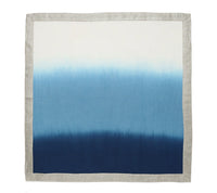The Kim Seybert Dip Dye Napkins - Cool Tones (Set of 4) feature a square linen design with a beige border and blue ombre fade, bringing a modern look to your table.