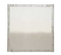 The Kim Seybert Dip Dye Napkins - Earthtones (Set of 4) feature a square linen design with a subtle gradient from light cream to light gray, accented by an elegant metallic foil border for added shimmer.