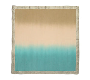 The Kim Seybert Dip Dye Napkins - Cool Tones - Set of 4 features a beige to cream and turquoise gradient, accented with a metallic foil border for elegance.