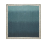 The Kim Seybert Dip Dye Napkins - Cool Tones - Set of 4 features a metallic foil border and gradient blue-to-teal design for an elegant table accent.