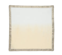 The Kim Seybert Dip Dye Napkins - Earthtones (Set of 4) feature a white and light beige gradient center, elegantly accented with a metallic foil border for added shine.