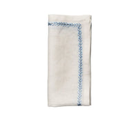 The Kim Seybert Jardin Napkin Set of 4 features folded white linen napkins with blue embroidered borders, displayed on a white background—an elegant choice for any formal dinner setting.