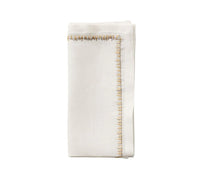 The Kim Seybert Filament Napkin Gold & Silver Set of 4 features embroidered linen napkins with elegant contrasting stitching, perfect for festive tablescapes. Shown neatly folded against a simple white background.
