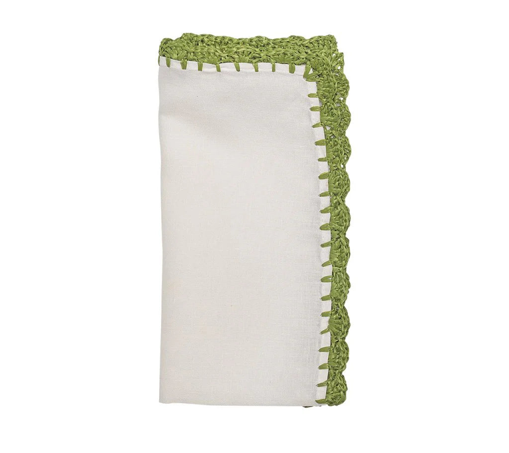 The Shell Edge Napkin Set of 4 by Kim Seybert features folded white linen napkins with decorative green crochet trim, perfect for a rustic table setting, shown against a white background.