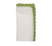 The Shell Edge Napkin Set of 4 by Kim Seybert features folded white linen napkins with decorative green crochet trim, perfect for a rustic table setting, shown against a white background.