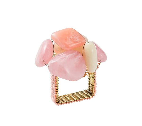 The Kim Seybert Sea Stone Napkin Ring Blush Set of 4 features gold square rings topped with large pink blush resin stones and a beaded band, evoking the elegance of beaded jewelry.