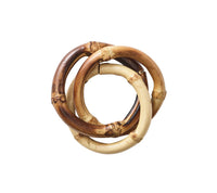 The Kim Seybert Bamboo Trinity Napkin Ring Set of 4 features interlocking bamboo rings in brown and beige, adding style and sustainability to your table decor.