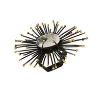 The Kim Seybert Flare Napkin Ring Black & Gold Set of 4 features a handmade starburst design with a central translucent stone, radiating black metal spokes, and gold sphere accents.