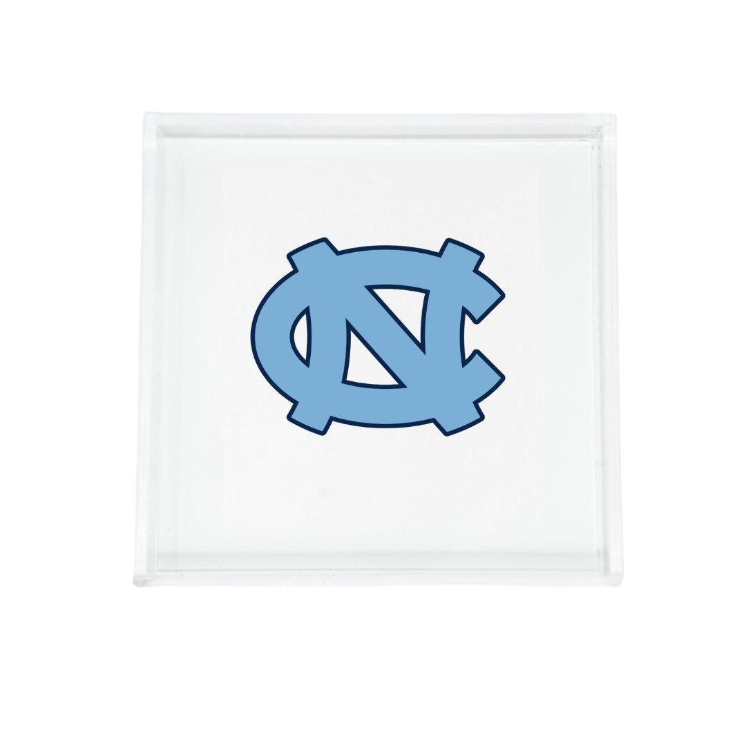 The Eye Candy College Acrylic Catchall Tray features the University of North Carolina at Chapel Hill’s interlocking NC logo in light blue—a stylish and functional dorm accessory for any Tar Heel fan.