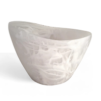 A modern, asymmetrical white bathtub with a smooth, marbled pattern reminiscent of the Nashi Home Oceania Ice Bucket & Chiller Vessel - White Swirl, featuring gently curved sides against a plain white background.