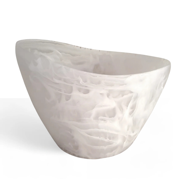 A modern, asymmetrical white bathtub with a smooth, marbled pattern reminiscent of the Nashi Home Oceania Ice Bucket & Chiller Vessel - White Swirl, featuring gently curved sides against a plain white background.