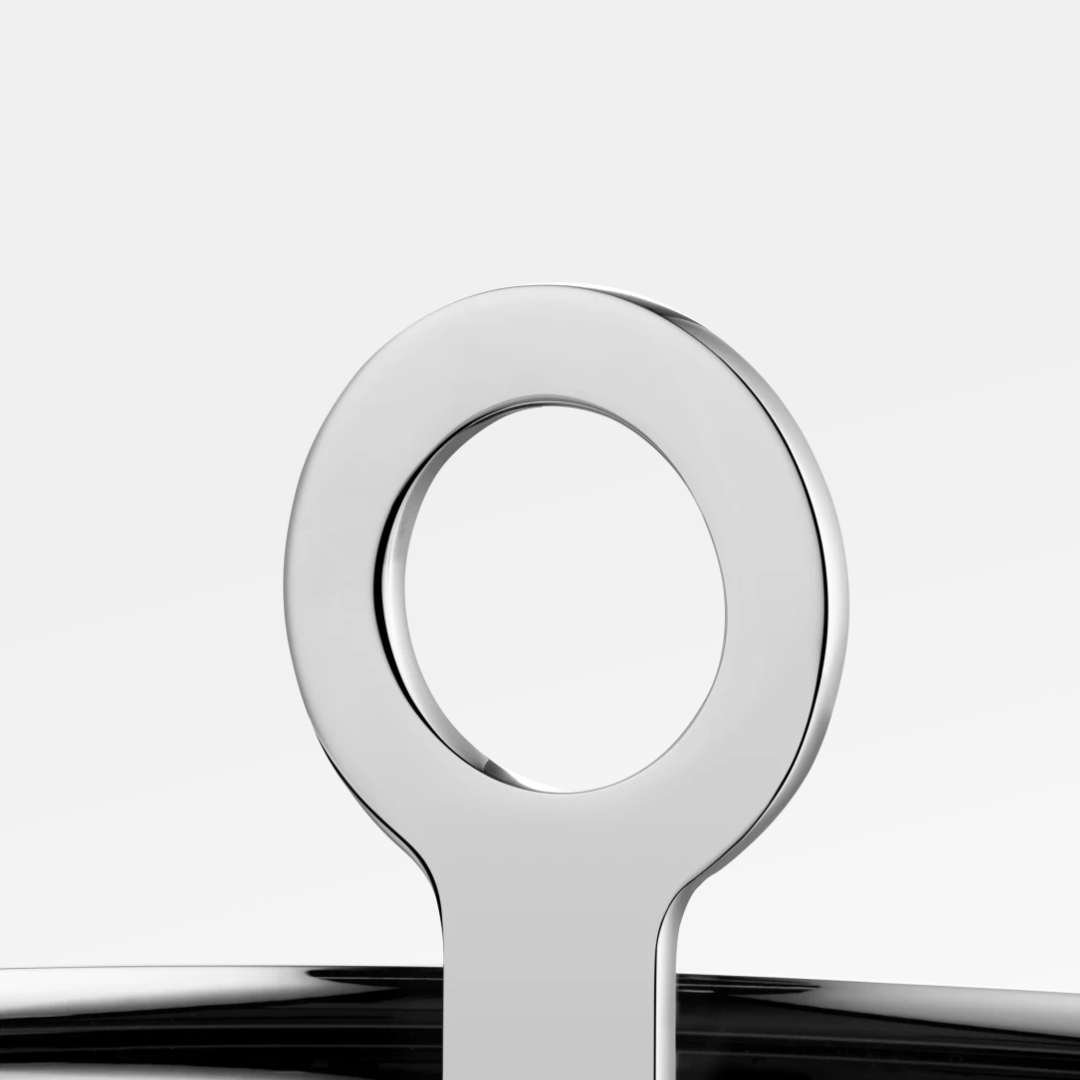 Close-up of the shiny, circular handle on the Oh De Christofle Stainless Steel Appetizer Plate by Christofle, set against a plain white background.
