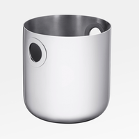 The Christofle Oh De Stainless Steel Champagne Bucket is a sleek, cylindrical barware essential with a smooth finish and two round handle openings near the top, shown against a plain white background.
