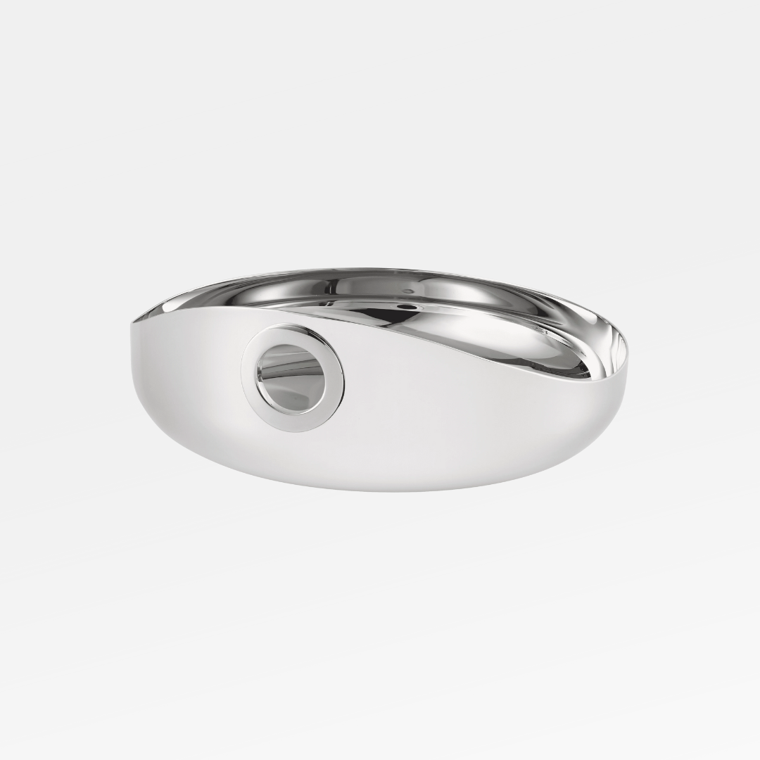 The Oh De Small Stainless Steel Bowl by Christofle features a sleek, modern oval design with a smooth, reflective finish and a unique circular cutout—perfect as a stylish multi-purpose bowl or wine coaster.