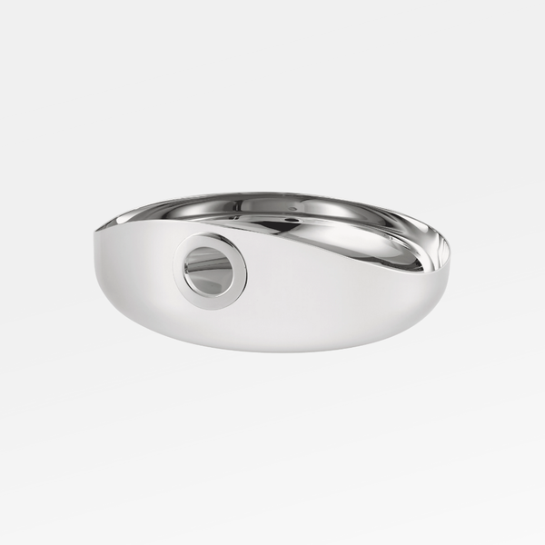 The Oh De Small Stainless Steel Bowl by Christofle features a sleek, modern oval design with a smooth, reflective finish and a unique circular cutout—perfect as a stylish multi-purpose bowl or wine coaster.