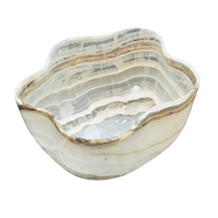 The Verona Prive Onyx Patina Centerpiece Bowl features a wavy edge, beige and white natural striations, a polished finish, hand-carved luxury design, and includes a drain hole at the bottom.