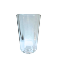 The Optic Everyday Cup Clear by Gary Bodker is a smooth-sided glass tumbler with a thick base, inspired by the artist’s handblown designs and displayed here against a plain white background.