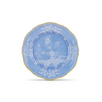 The Ginori 1735 Oriente Italiano Pervinca Dinner Plate features a white background with blue floral and landscape motifs, scalloped edges, and a fine 24k gold trim.