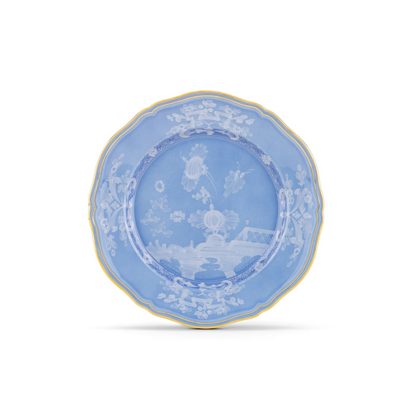 The Ginori 1735 Oriente Italiano Pervinca Dinner Plate features a white background with blue floral and landscape motifs, scalloped edges, and a fine 24k gold trim.