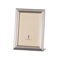 The Oscar Frame Platinum by L'Objet is a silver rectangular frame with a ridged border and sleek angular design, standing upright to display a blank insert featuring the L'Objet logo at the center.