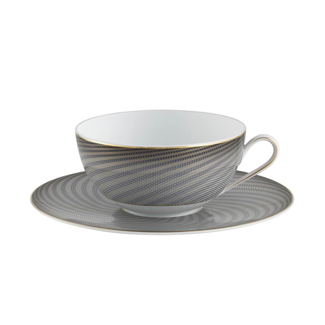 The Raynaud Oskar Dinnerware teacup with handle and matching saucer features fine blue and gold geometric lines with a gold rim on white Limoges porcelain.