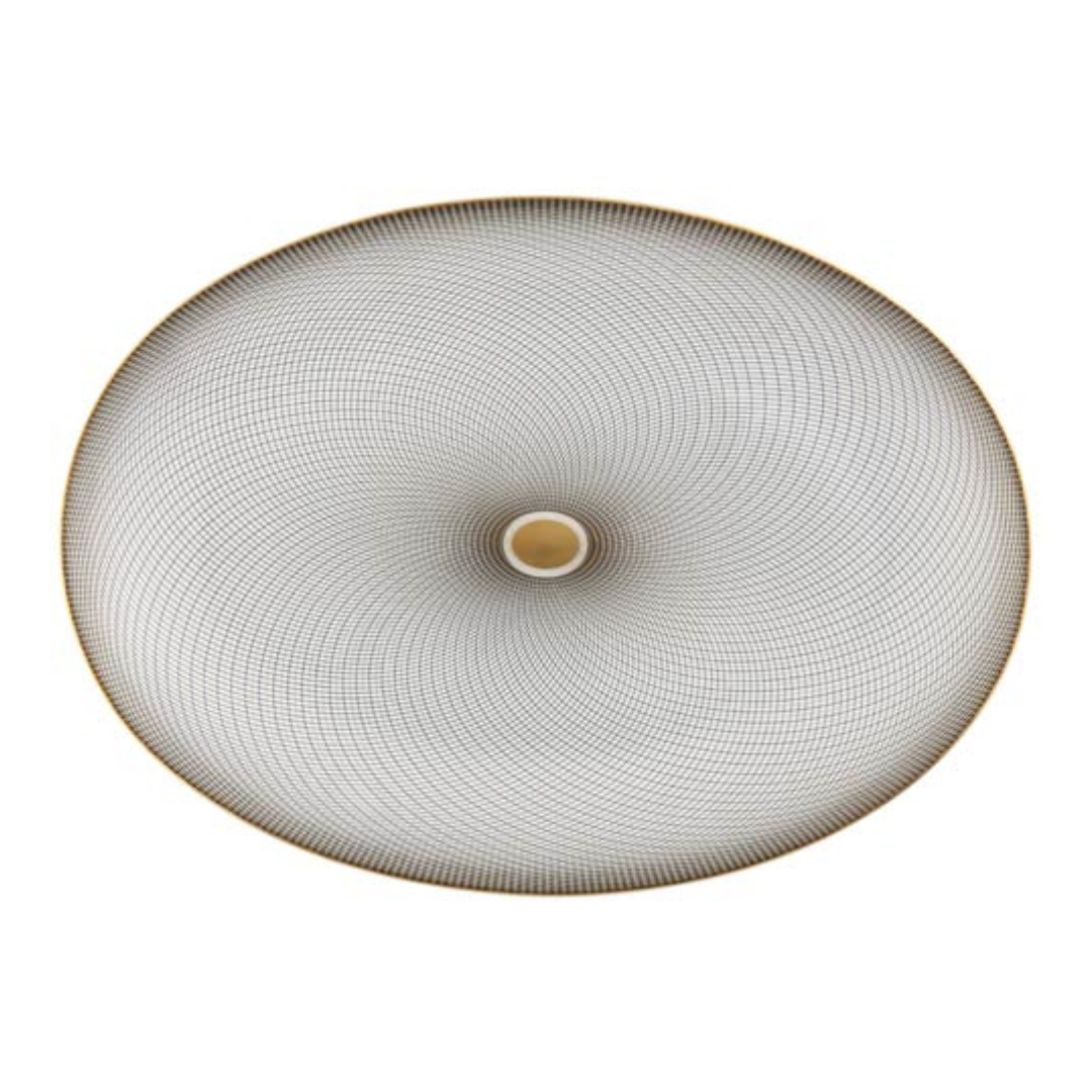 The Oskar Dinnerware by Raynaud features a swirling geometric design of black lines radiating from a beige center, evoking Limoges porcelain on a white background.
