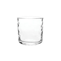 A clear, empty glass tumbler from Juliska’s Puro Glassware collection, featuring a subtly textured surface, is set against a plain white background.