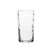 A clear, empty cylindrical glass tumbler from Juliska’s Puro Glassware collection features a smooth rim and subtly textured sides, displayed against a plain white background.