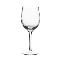 The Juliska Puro Glassware wine glass features a long stem and a textured, dimpled bowl. Dishwasher safe, it stands upright empty on a white background.