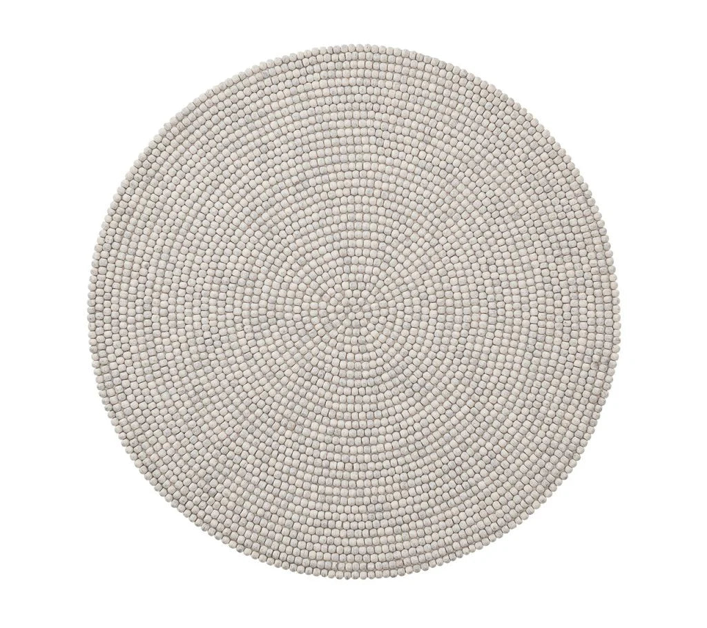 Round, light gray placemats from the Driftwood Placemat Set 4 Grey by Kim Seybert feature pebble-like texture and even design, offering a unique touch to handcrafted table decor or pairing beautifully with a beaded placemat. Seen from above on a white background.
